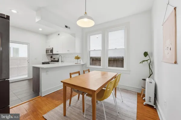a kitchen with a table chairs refrigerator and microwave