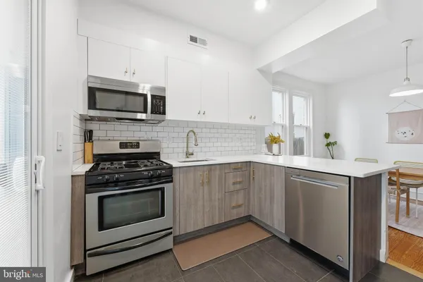 a kitchen with cabinets stainless steel appliances and white cabinets