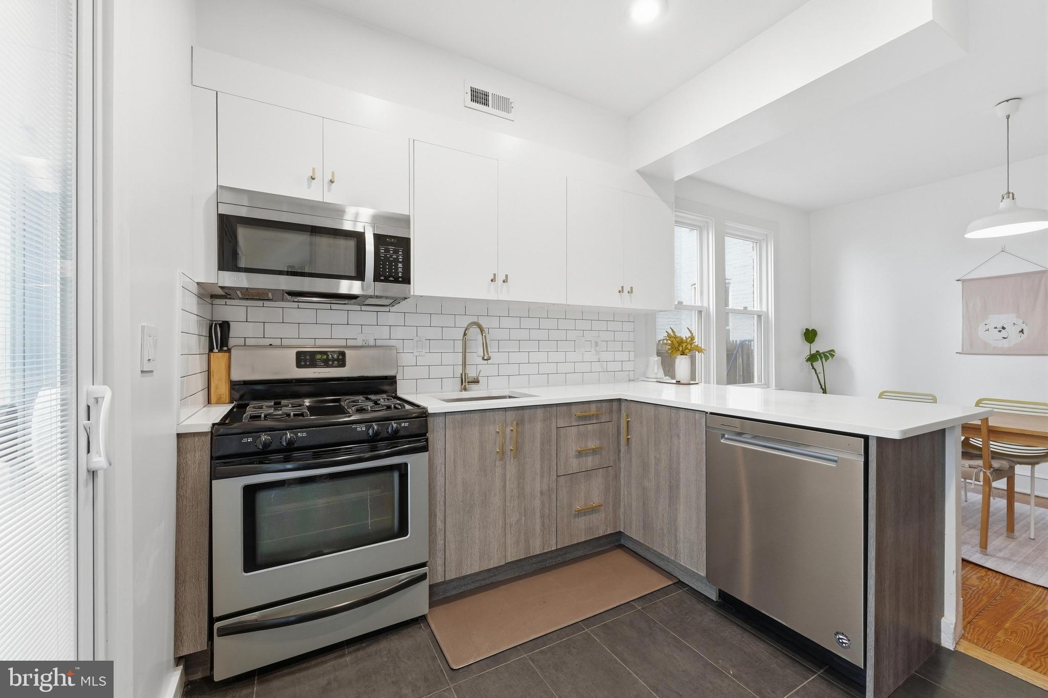 215 15th Street Northeast Washington, DC 20002 - Photo 10 of 43 a kitchen with cabinets stainless steel appliances and white cabinets