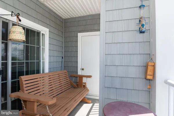 a view of a balcony with wooden floor and bench