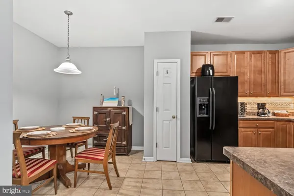a kitchen with stainless steel appliances granite countertop a refrigerator a sink a stove and chairs