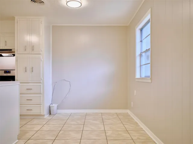 a kitchen with cabinets and chairs