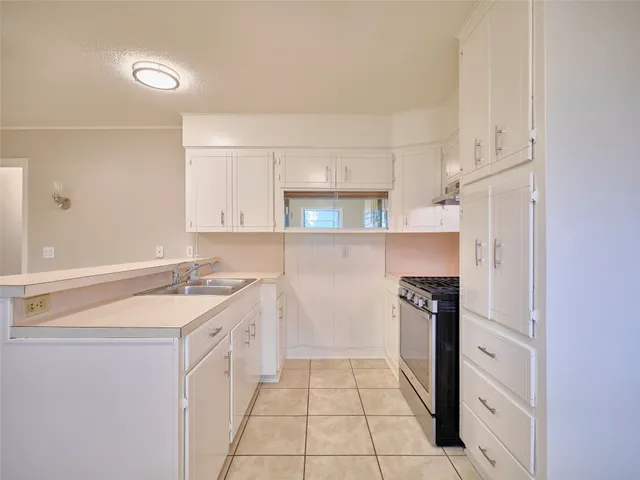 a kitchen with stainless steel appliances granite countertop white cabinets and a stove