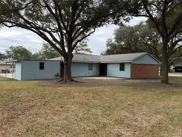 a white house that has a tree in front of it