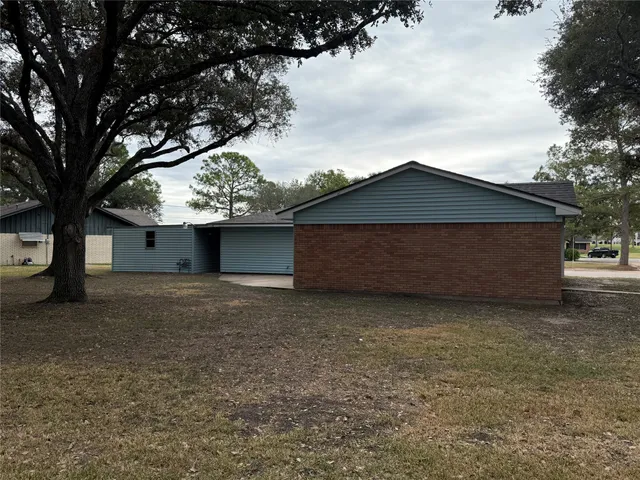 a backyard of a house with large trees and a large tree