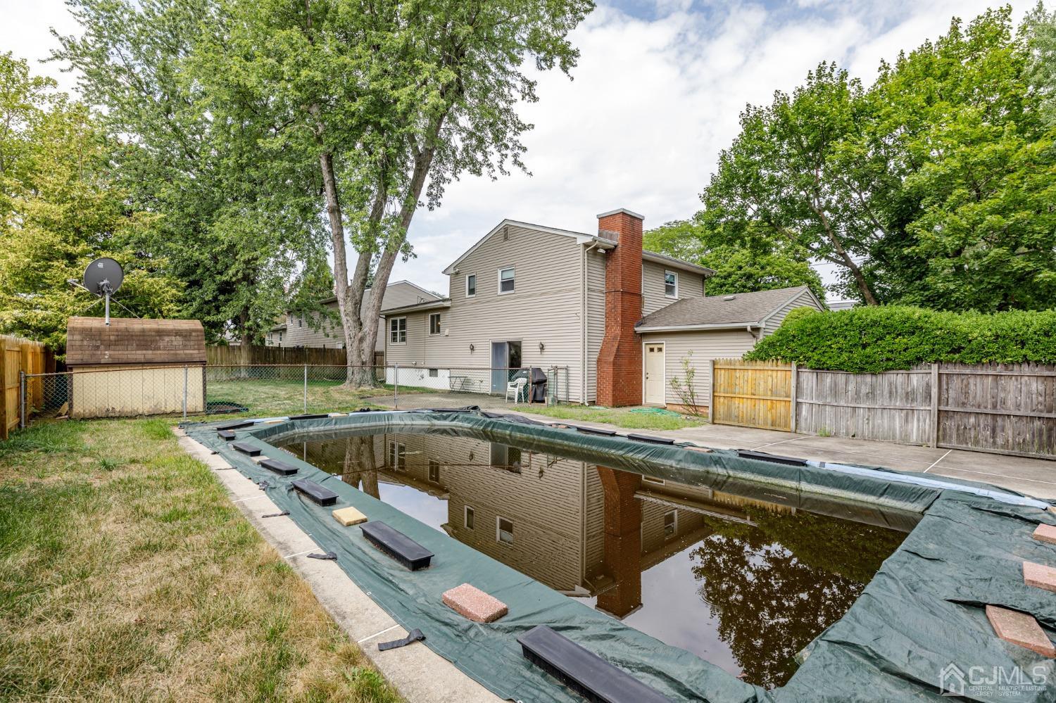 38 Marlin Avenue East Edison, NJ 08820 - Photo 35 of 36 a view of a backyard with a large pool and wooden fence