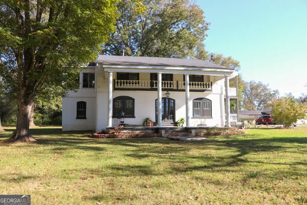 a front view of house with yard path and trees