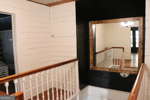 a view of a hallway with wooden floor and stairs