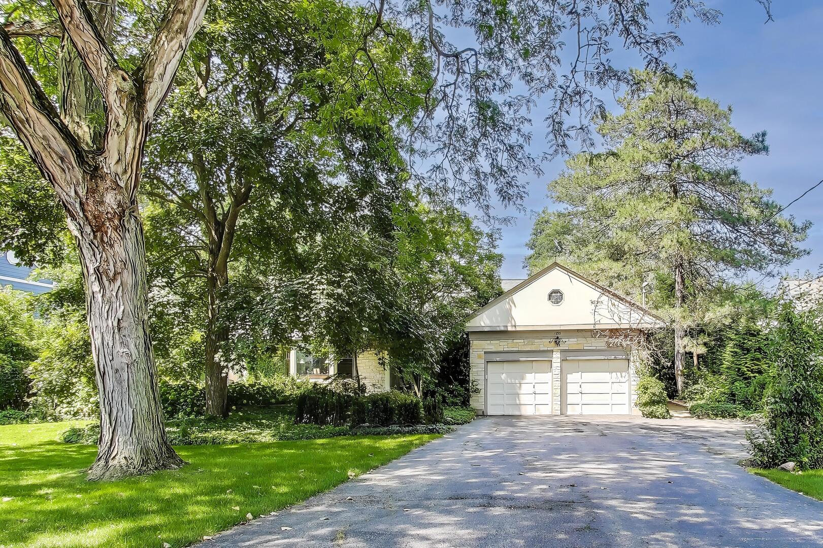 1295 Sunview Lane Winnetka, IL 60093 - Photo 1 of 8 a front view of a house with a garden and trees