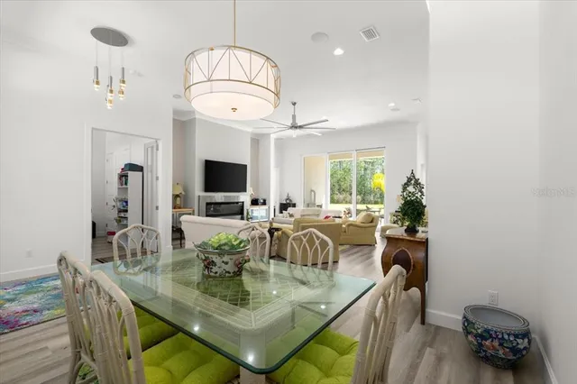 a view of a dining room with furniture a chandelier and wooden floor
