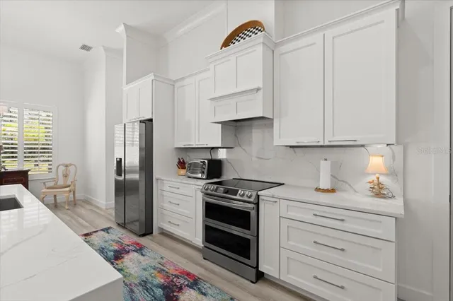 a kitchen with stainless steel appliances a stove a refrigerator and cabinets