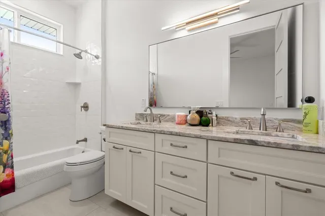 a bathroom with a granite countertop toilet sink and mirror