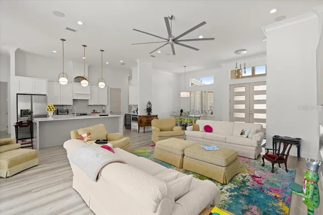 a living room with furniture kitchen and a chandelier