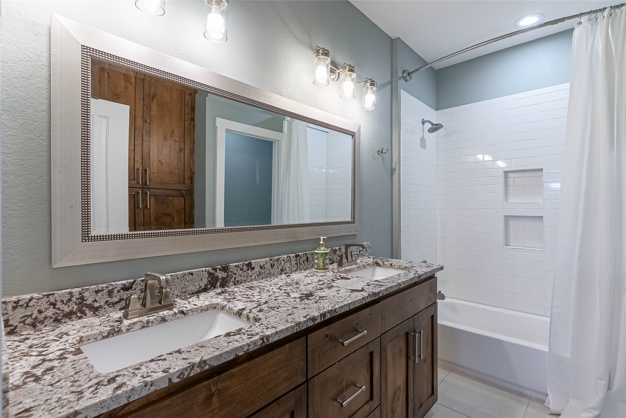 410 Summit Ridge Drive North Point Venture, TX 78645 - Photo 21 of 37 a bathroom with a granite countertop sink double vanity and a mirror