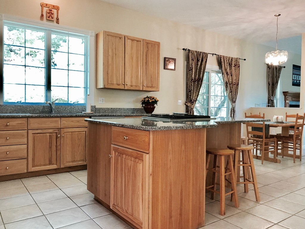 160 East Leverett Road Amherst, MA 01002 - Photo 9 of 30 a kitchen with stainless steel appliances granite countertop a sink a stove a dining table and chairs