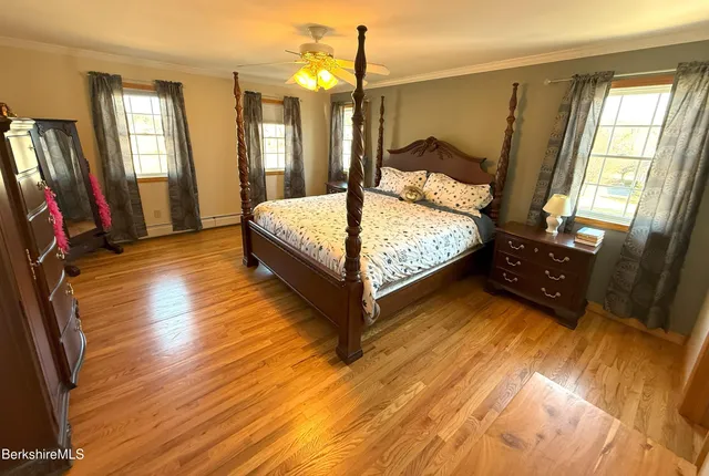 a bedroom with a bed window and wooden floor