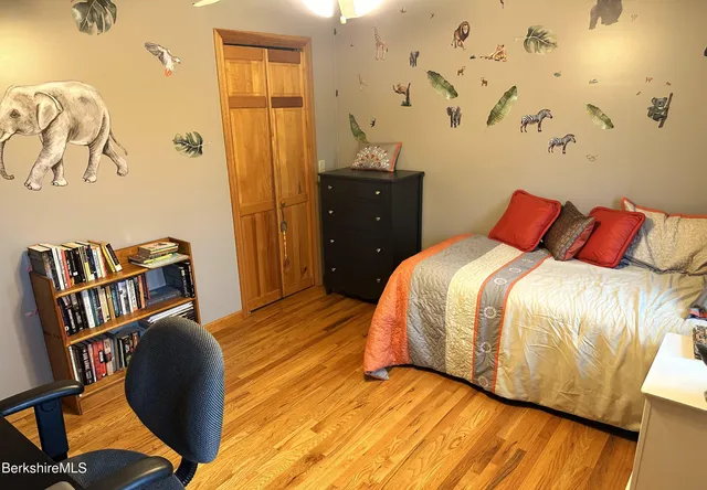 a bedroom with a bed and wooden floor