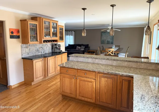 a kitchen with stainless steel appliances granite countertop wooden floors and granite counter tops