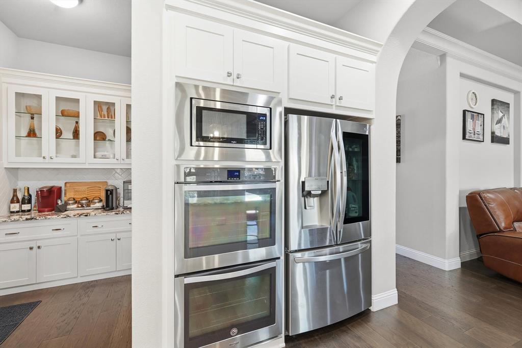 529 Prairie Run Aledo, TX 76008 - Photo 14 of 40 a kitchen with stainless steel appliances white cabinets and wooden floors