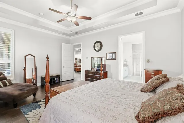 a bedroom with a bed mirror and a large window