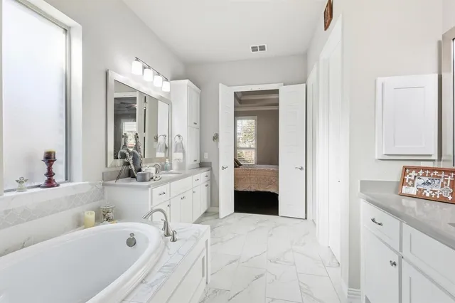a bathroom with a tub sink and mirror