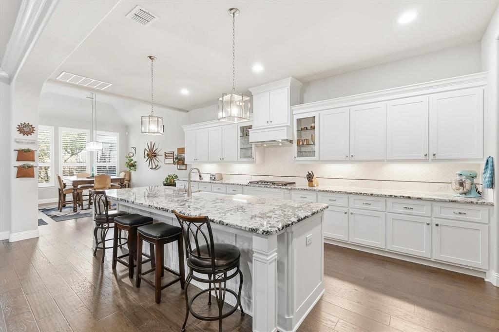 529 Prairie Run Aledo, TX 76008 - Photo 3 of 40 a kitchen with granite countertop white cabinets and wooden floor