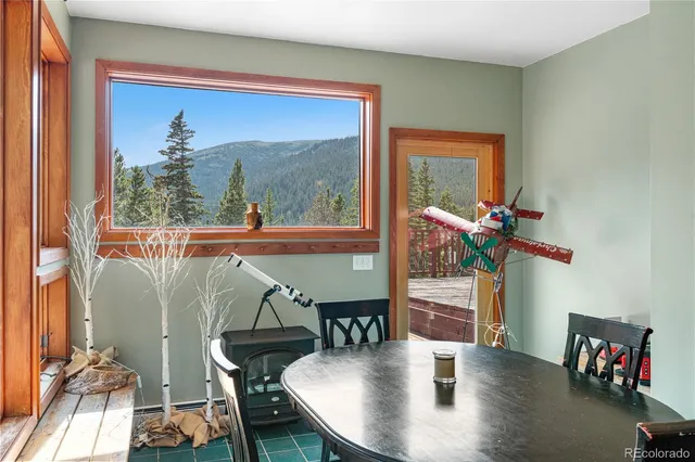 a dining room with furniture a floor to ceiling window and wooden floor