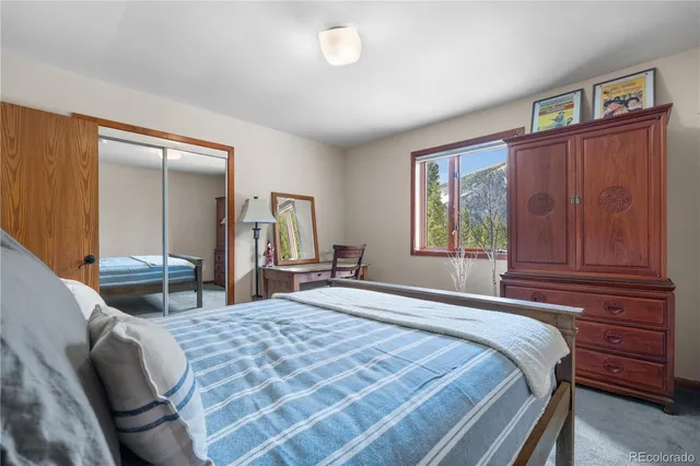 a bedroom with a bed and dresser with mirror