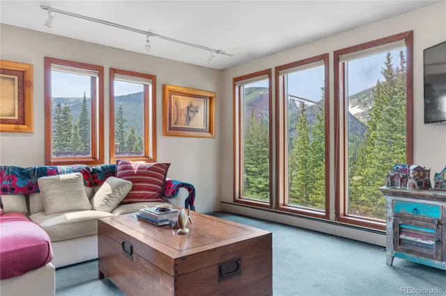 a living room with furniture and floor to ceiling windows