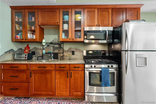 a kitchen with stainless steel appliances granite countertop a refrigerator and a stove top oven