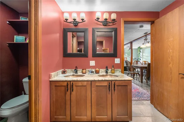 a spacious bathroom with a granite countertop sink a toilet and a mirror