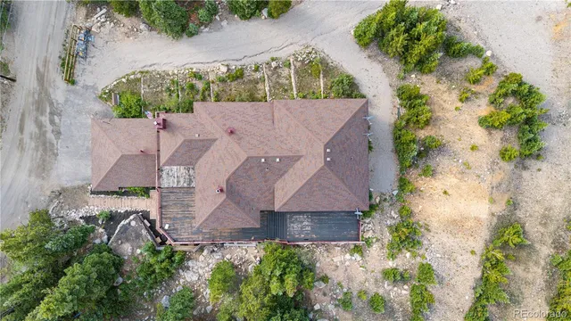 an aerial view of a house with a yard and a large tree