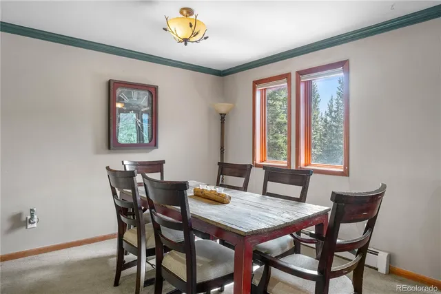a view of a dining room with furniture a rug and a window