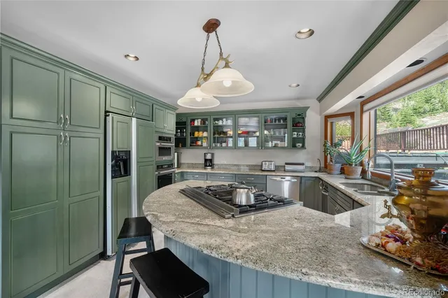 a kitchen with granite countertop a sink stove and refrigerator