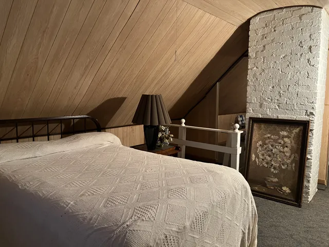 a bedroom with a bed and a painting on the wall