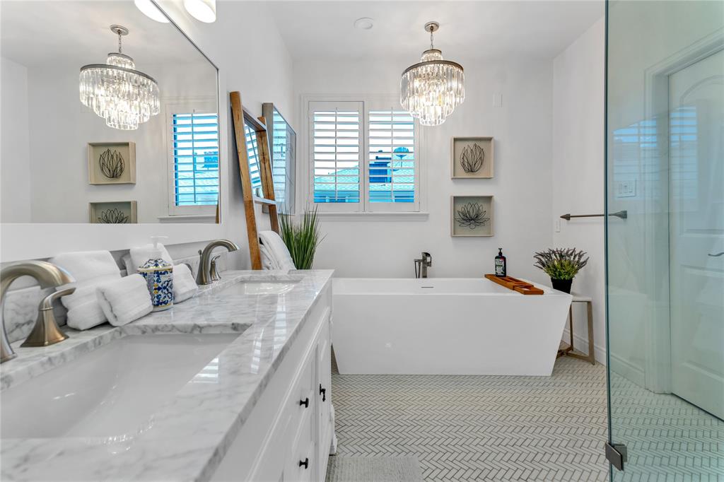 5744 Robbie Road Plano, TX 75024 - Photo 28 of 32 Bathroom featuring a dual vanity with a stone countertop, a freestanding soaking tub, and a separate glass-enclosed shower