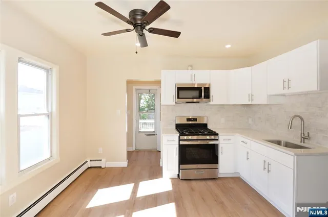 a kitchen with a sink appliances and cabinets