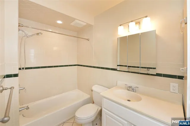 a bathroom with a sink a mirror toilet and bathtub