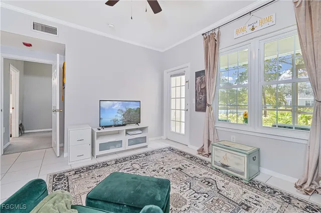 a living room with furniture a flat screen tv and a floor to ceiling window