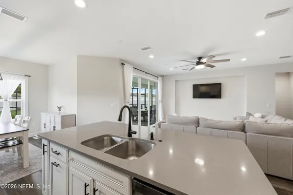 a spacious bedroom with a bed and a chandelier fan