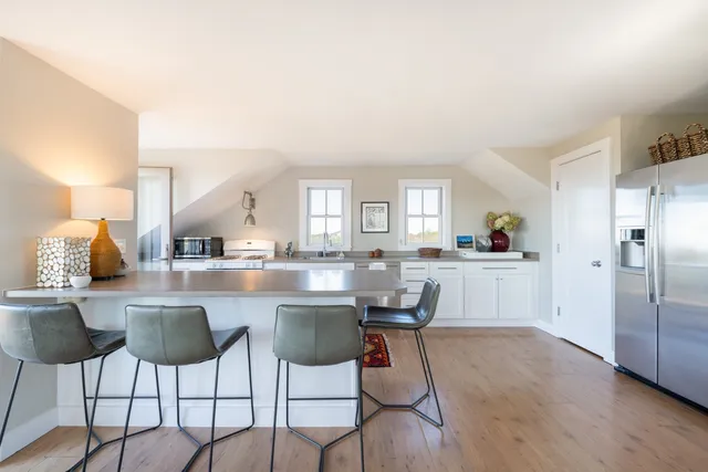 a kitchen with stainless steel appliances kitchen island granite countertop a table and chairs