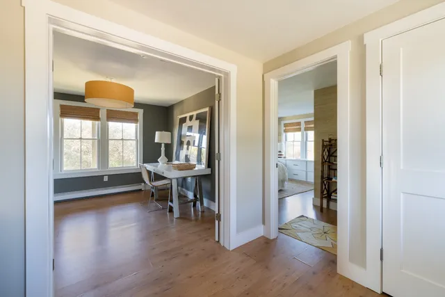 a view of a dining room with hardwood floor and a living room