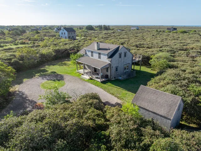 an aerial view of a house with a garden and lake view