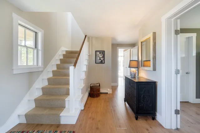 a view of entryway and hall with wooden floor