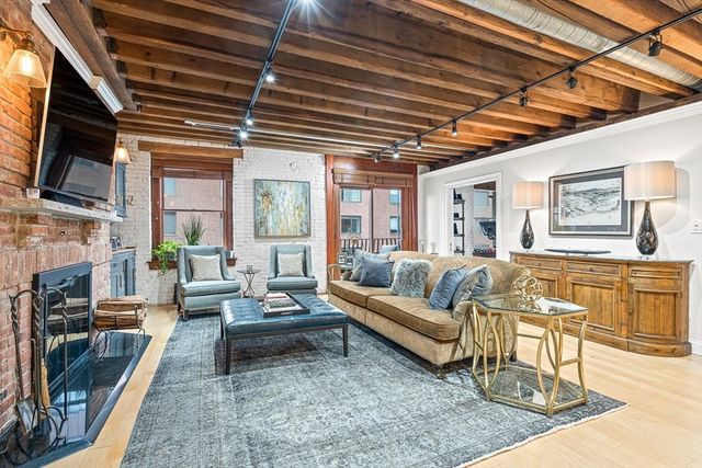 a living room with fireplace furniture and a rug