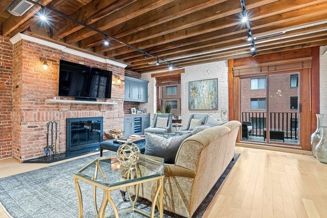 a living room with furniture a fireplace and a flat screen tv