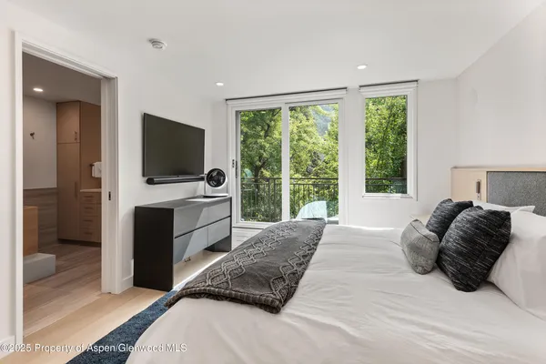 a bedroom with a bed and a flat screen tv