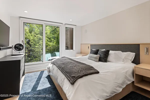 a bedroom with a bed a fireplace and a large window