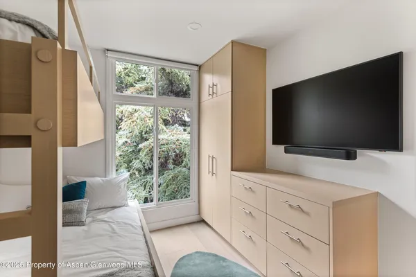 a living room with flat screen tv and a floor to ceiling window