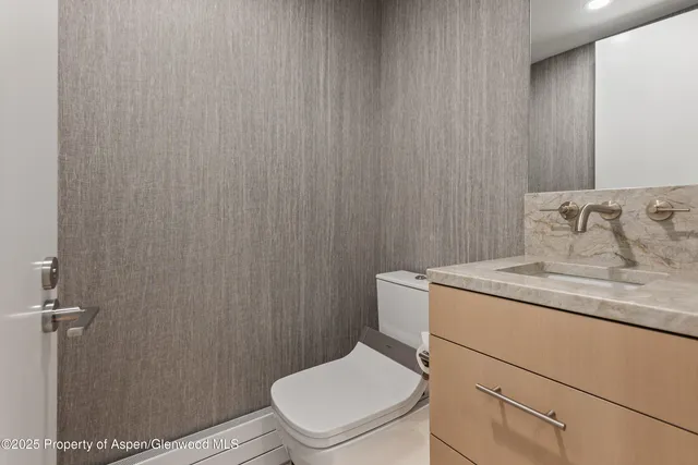 a bathroom with a granite countertop sink toilet and a mirror